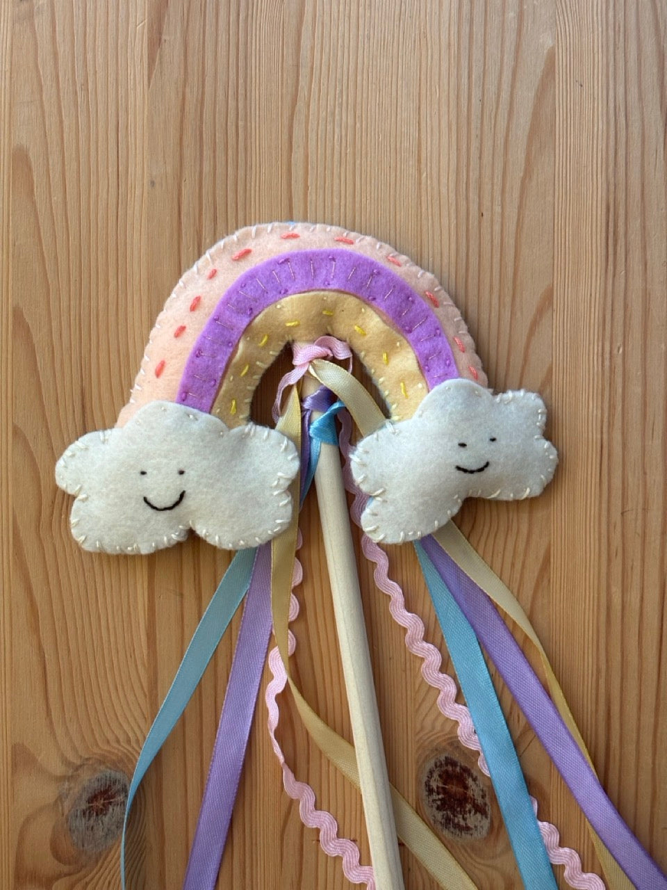 felt rainbow and cloud design on a wooden background
