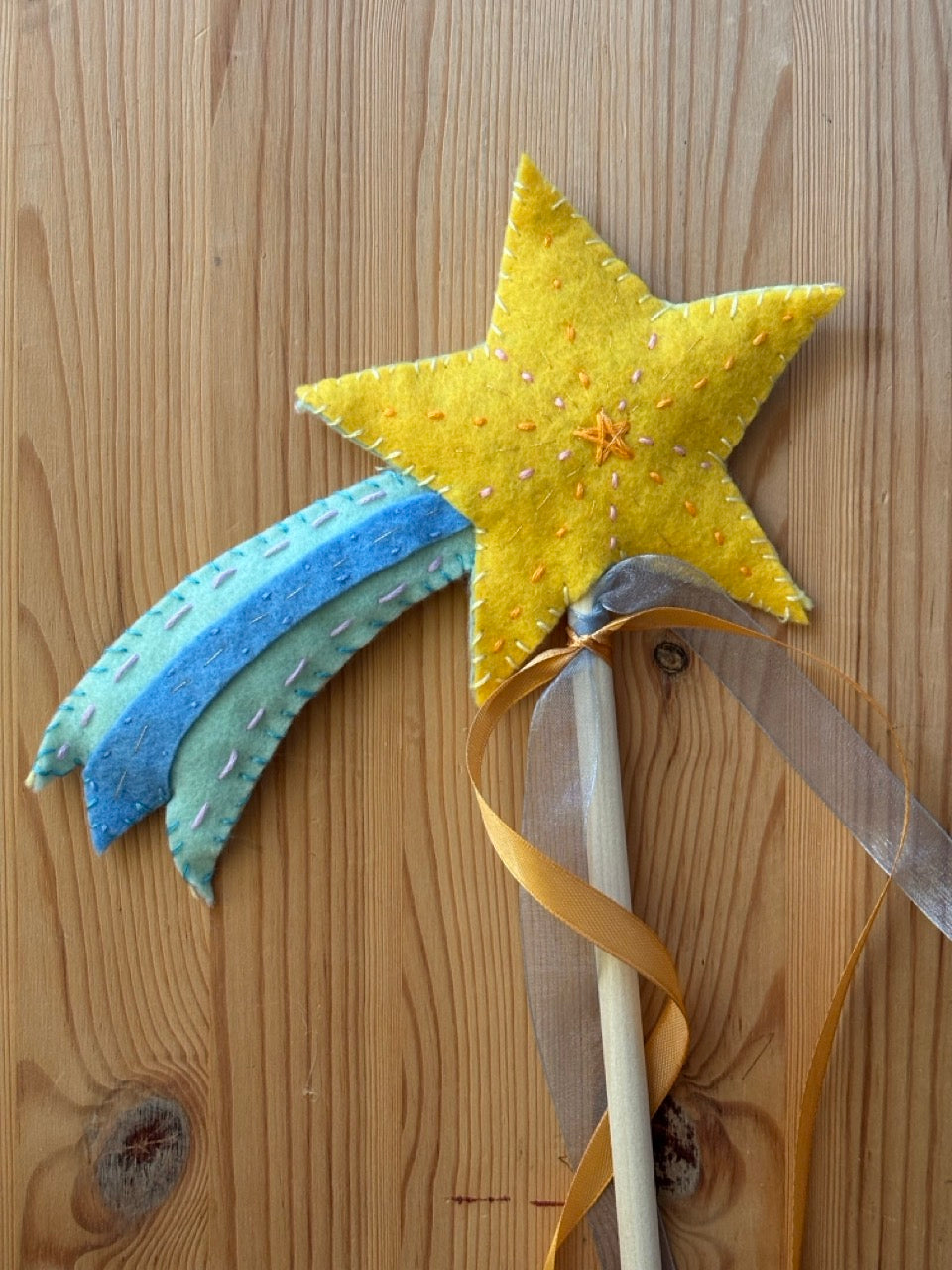 Felt shooting star wand on a wooden surface